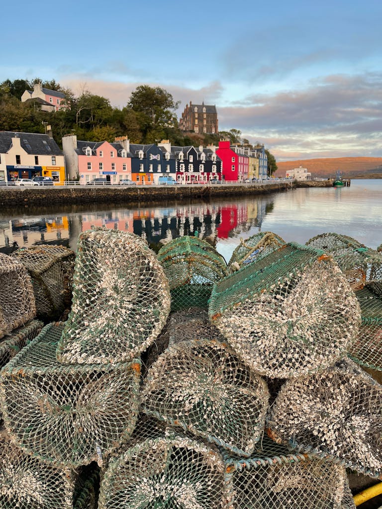 Vibrant harbor houses and stacked fishing nets at daybreak.